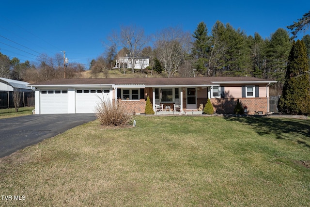 view of front of home with brick siding, covered porch, an attached garage, driveway, and a front lawn