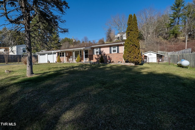 view of front facade with an attached garage, brick siding, fence, and a front lawn