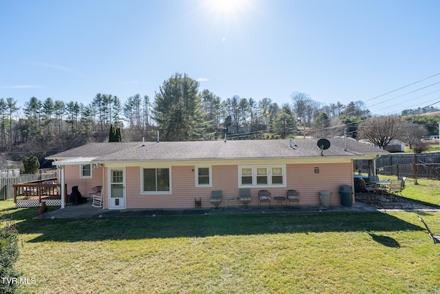 back of house featuring a patio, a lawn, fence, and a wooden deck