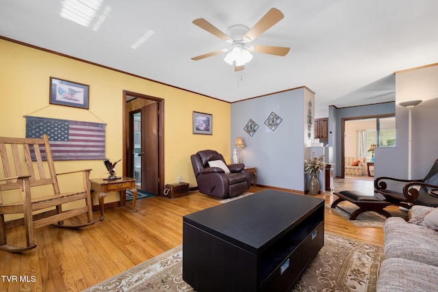 living room featuring light wood-type flooring, ceiling fan, and crown molding