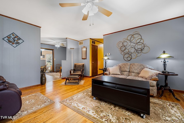 living room with baseboards, ceiling fan, visible vents, and wood finished floors