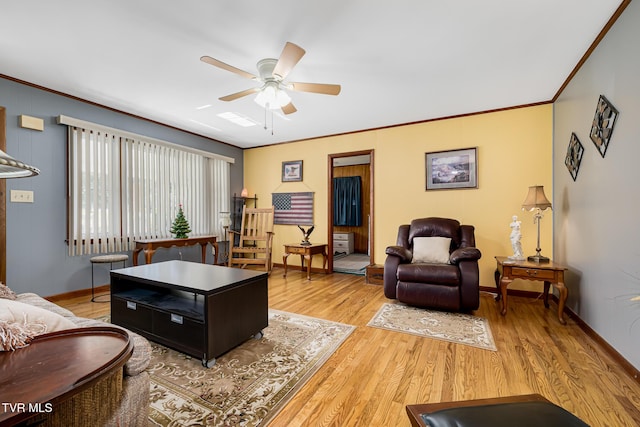 living area with baseboards, light wood-style floors, a ceiling fan, and crown molding