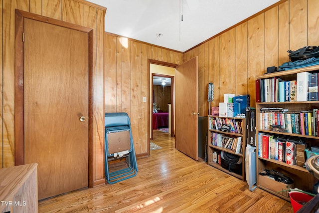 interior space with wood walls, ornamental molding, and wood finished floors