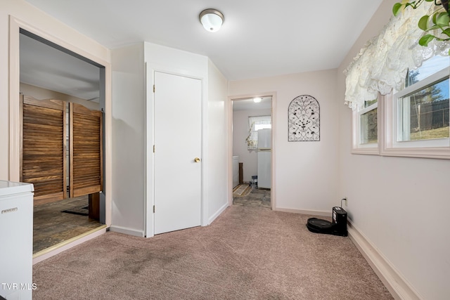 interior space with carpet flooring, plenty of natural light, and baseboards