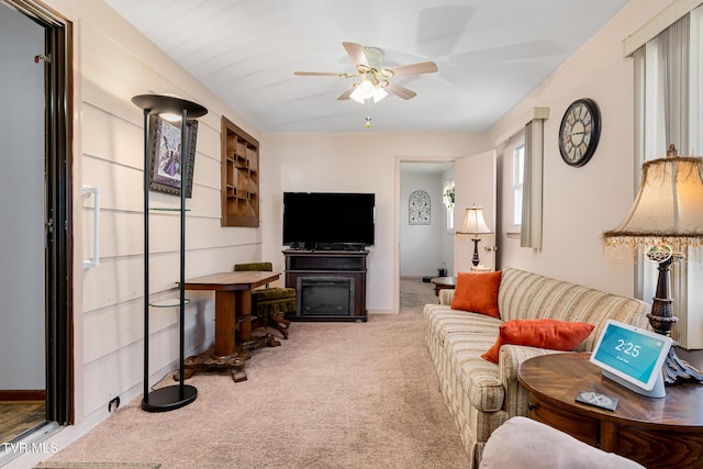 carpeted living room featuring ceiling fan and baseboards