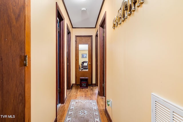 corridor featuring visible vents and light wood finished floors