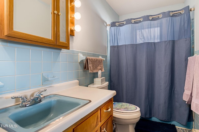 bathroom with toilet, a shower with curtain, tile walls, and vanity