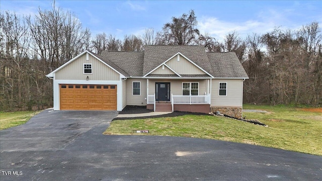 view of front of property with a porch, a garage, and a front lawn