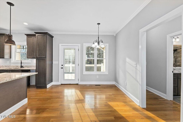 unfurnished dining area featuring crown molding, dark wood-type flooring, and an inviting chandelier