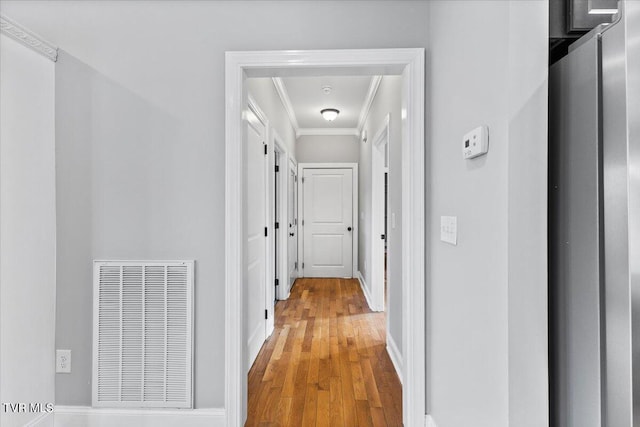 hall featuring hardwood / wood-style flooring and ornamental molding