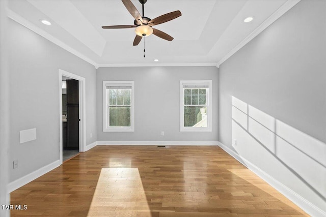 unfurnished room with wood-type flooring, ceiling fan, and a tray ceiling