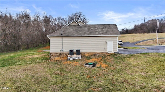 view of side of home featuring a yard and cooling unit