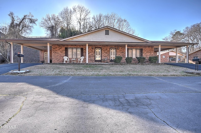 ranch-style home with a carport and a porch