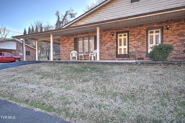 ranch-style house featuring a porch and a front lawn