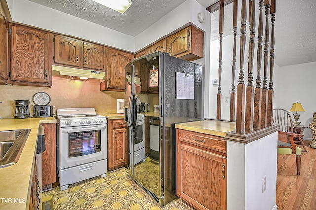 kitchen featuring sink, a textured ceiling, and white range with electric cooktop