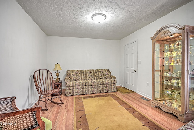 sitting room with hardwood / wood-style flooring and a textured ceiling