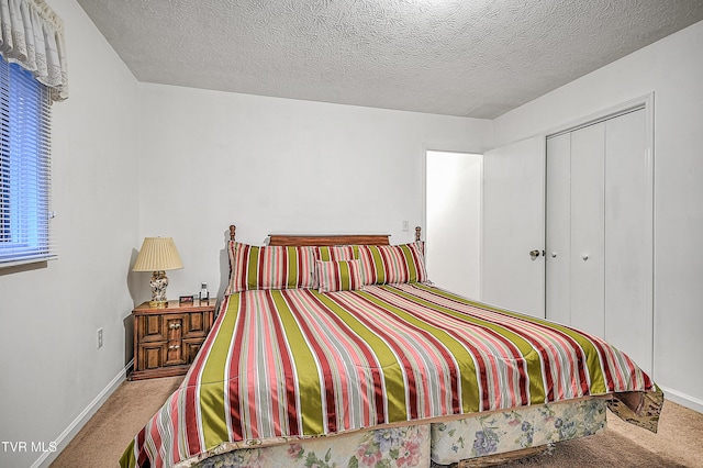 carpeted bedroom with a textured ceiling and a closet