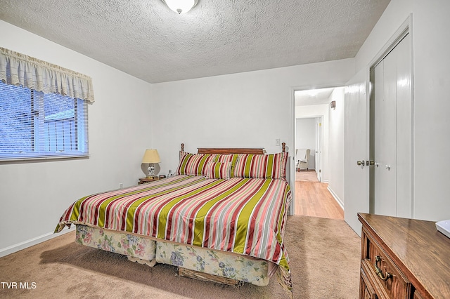 bedroom with light colored carpet, a closet, and a textured ceiling