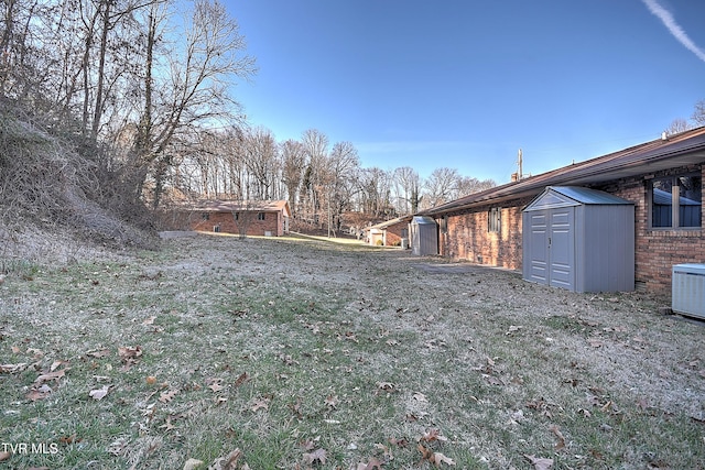 view of yard featuring central AC and a shed