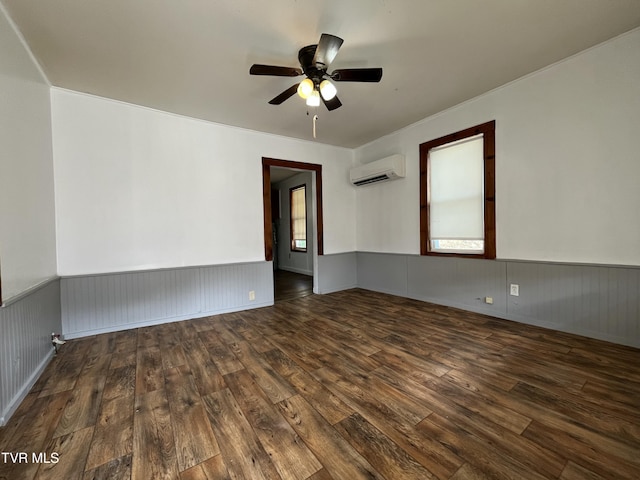 empty room with an AC wall unit, dark wood-type flooring, and ceiling fan