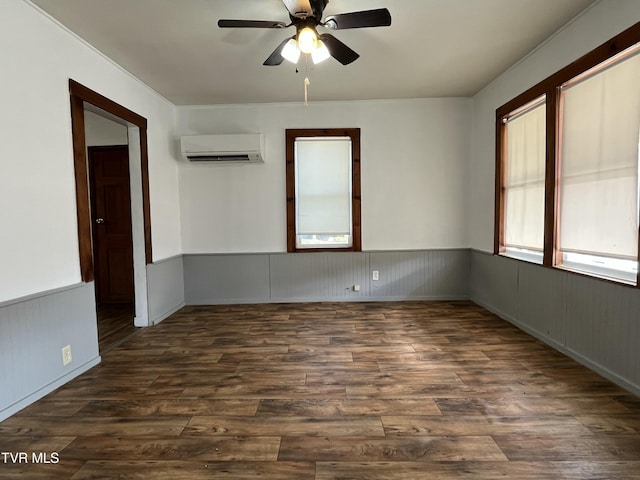 empty room with a wall mounted air conditioner, dark wood-type flooring, and ceiling fan