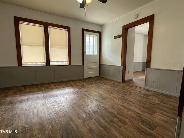 empty room with dark wood-type flooring and ceiling fan