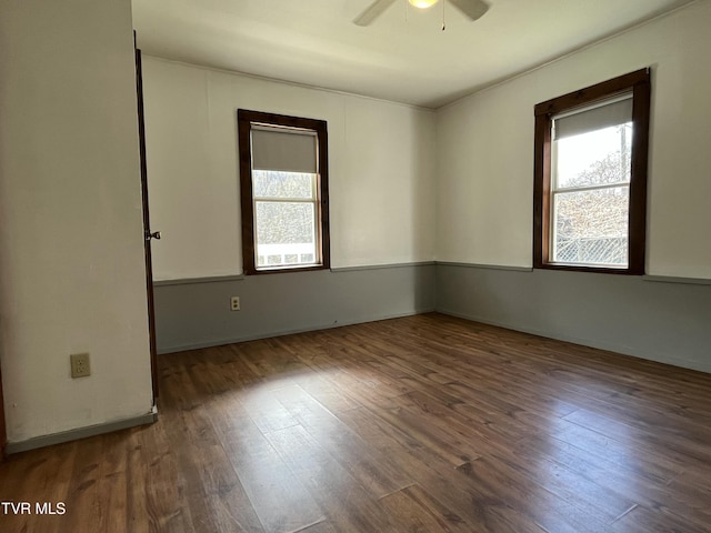 unfurnished room featuring dark wood-type flooring, ceiling fan, and a wealth of natural light