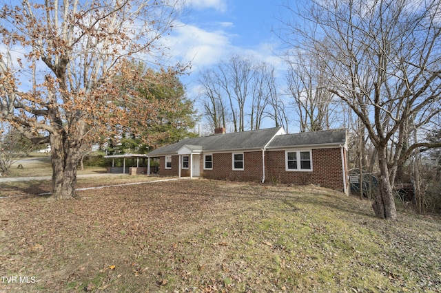 ranch-style house featuring a front lawn and a carport