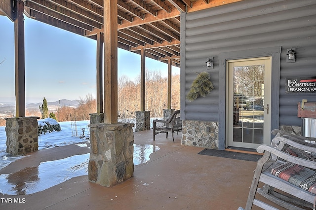 snow covered patio featuring a mountain view