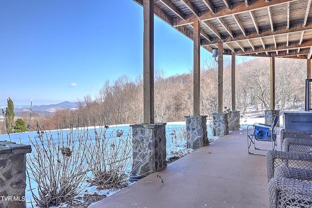 snow covered patio featuring a mountain view