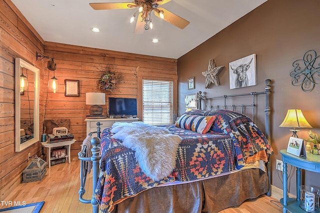 bedroom featuring light hardwood / wood-style flooring and wooden walls