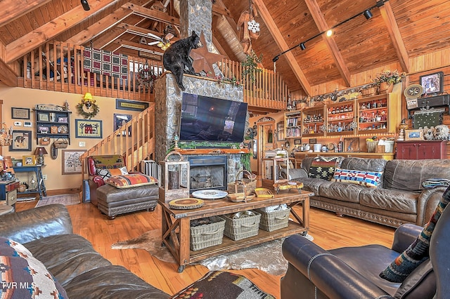 living room with beam ceiling, high vaulted ceiling, wooden ceiling, hardwood / wood-style flooring, and a fireplace