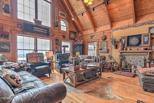 living room with beamed ceiling, wooden walls, hardwood / wood-style floors, and wooden ceiling