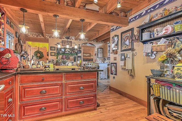 kitchen with beam ceiling, hanging light fixtures, wood ceiling, and light hardwood / wood-style flooring