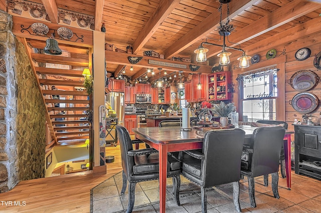 dining area with wood ceiling, wooden walls, light wood-type flooring, and beamed ceiling