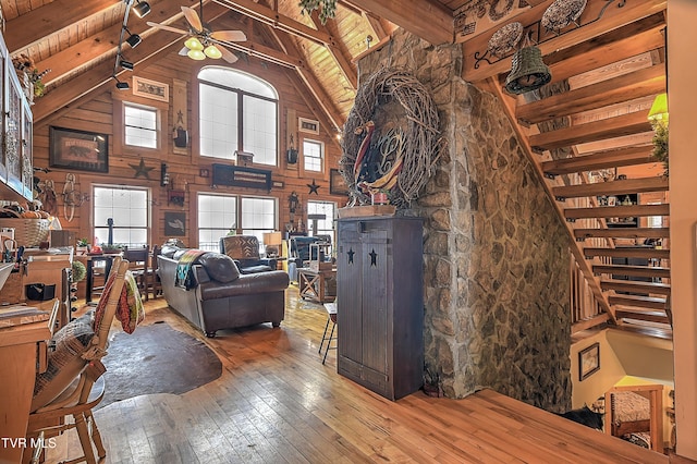 living room featuring ceiling fan, high vaulted ceiling, wood-type flooring, wooden ceiling, and beamed ceiling