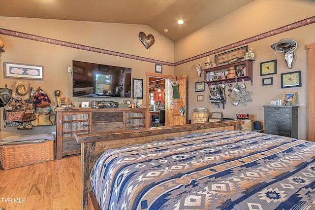 bedroom with light hardwood / wood-style floors and vaulted ceiling