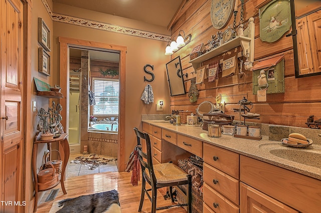 bathroom with a bathing tub, wood-type flooring, and vanity