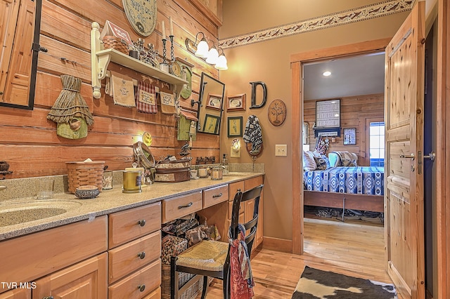 bathroom featuring vanity, hardwood / wood-style floors, and wooden walls