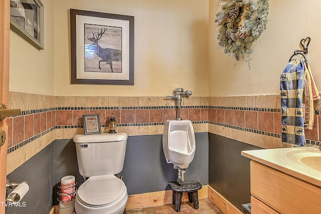 bathroom featuring vanity, toilet, and tile walls