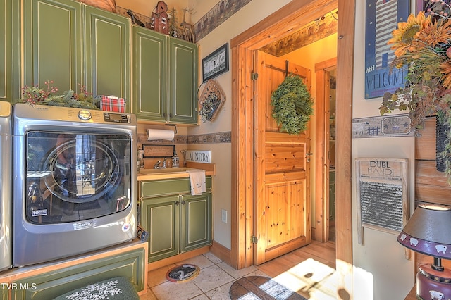 laundry area with washer / clothes dryer, light tile patterned floors, and cabinets