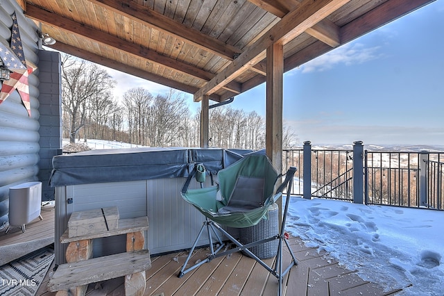 snow covered deck with a hot tub