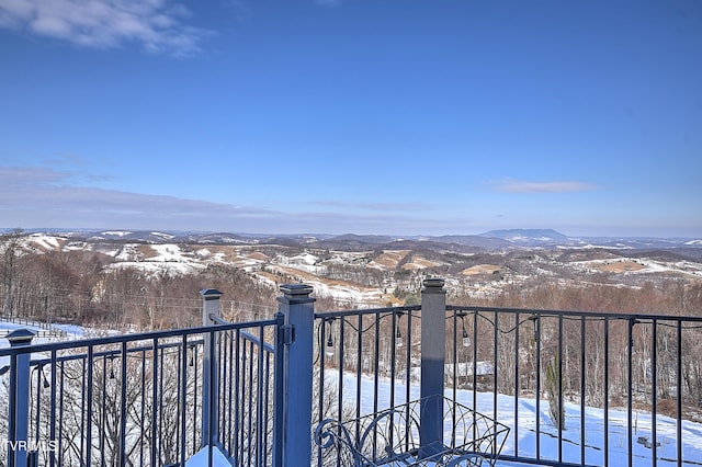 snow covered back of property featuring a mountain view