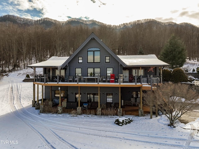 snow covered house featuring a mountain view