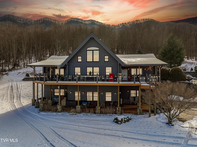 snow covered property featuring a deck with mountain view