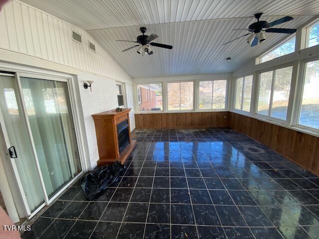 unfurnished sunroom with ceiling fan, wooden ceiling, lofted ceiling, and a wealth of natural light