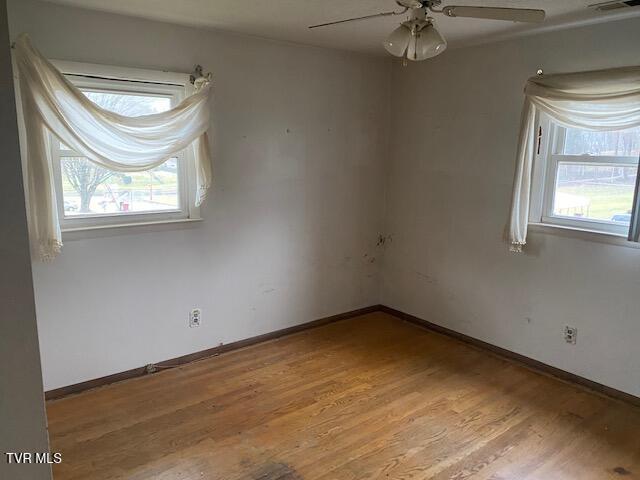 spare room with ceiling fan, plenty of natural light, and light hardwood / wood-style floors