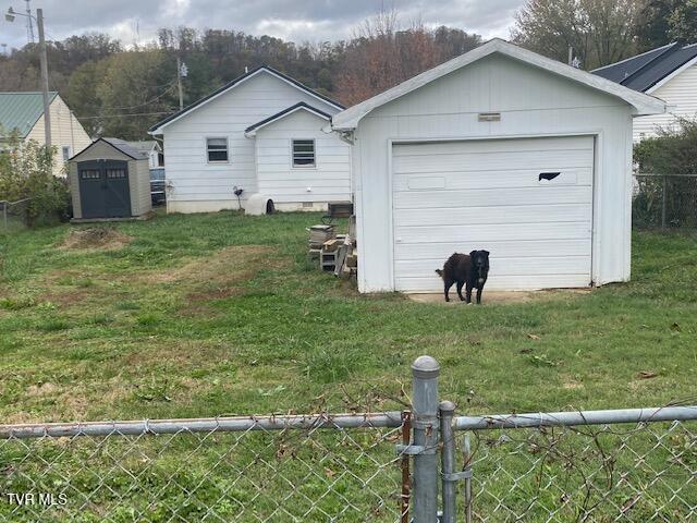 view of yard with a shed, an outdoor structure, and fence