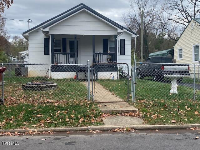 bungalow featuring a porch, a fenced front yard, a front lawn, and a gate