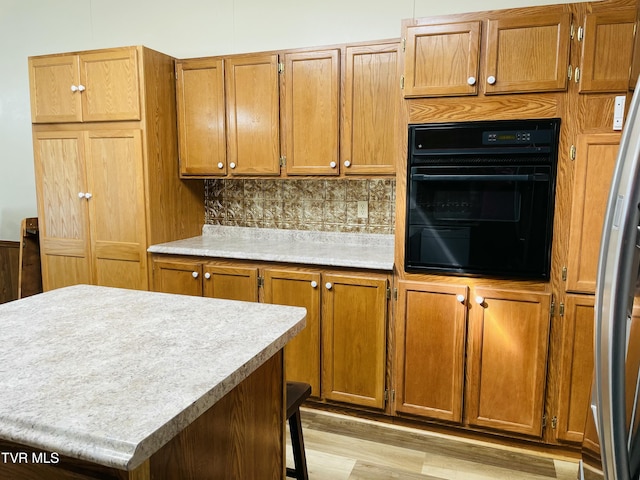 800 Buffalo Ridge Rd, Big Stone Gap, VA 24219 - kitchen featuring a kitchen island, tasteful backsplash, oven, stainless steel refrigerator with ice dispenser, and light hardwood / wood-style flooring